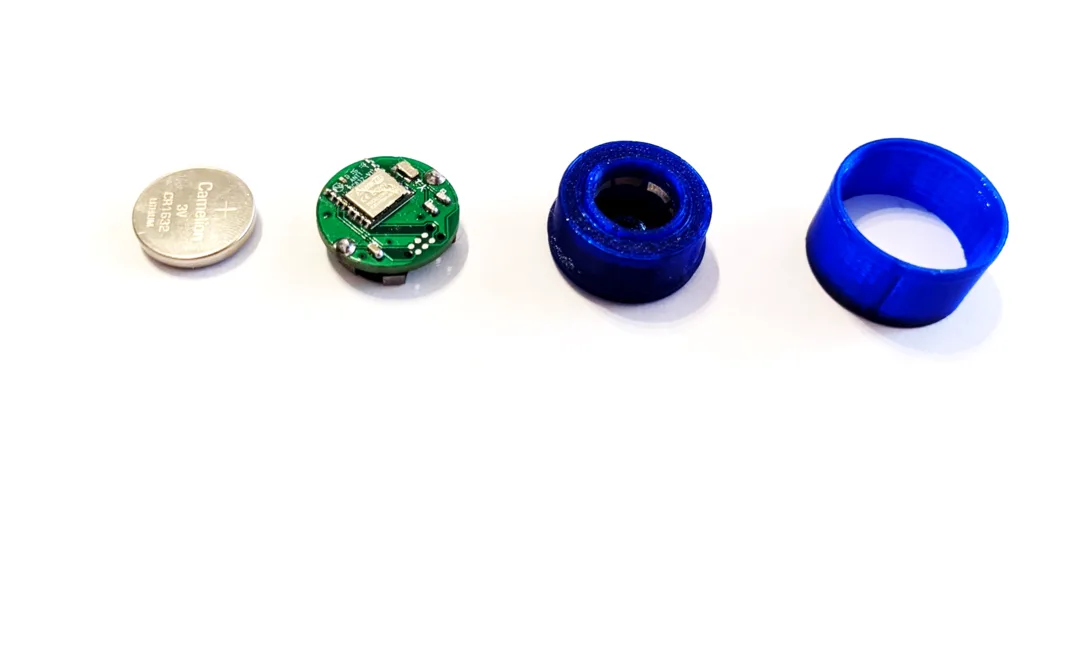 Tag components: coin cell, circuit board and blue 3D-printed casing